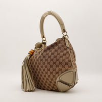 Gucci Indy Hobo vue de trois quarts gauche toile GG Canvas beige detail poignee rigide — AMANA Vintage