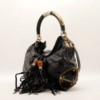 Gucci Indy Hobo noir vue de profil avec bandoulière dorée et pompons — AMANA Vintage