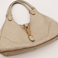 Détail fermoir piston doré Gucci New Jackie cuir Guccissima taupe — AMANA Vintage