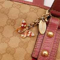 Détail breloque papillon cristaux Gucci et plaque signature dorée — AMANA Vintage