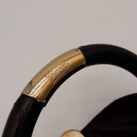 Détail plaque dorée Gucci sur anse bambou gainé rayures visibles — AMANA Vintage