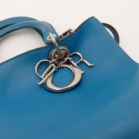 Detail breloque lettres Dior argentees sur sac Diorissimo bleu canard — AMANA Vintage